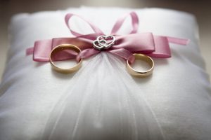 Gold wedding rings on a white pillow