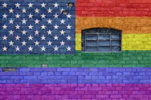American pride flag painted on a brick wall.