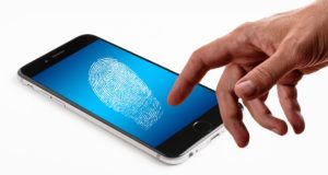 Hand in front of a smart phone with biometrics fingerprint.