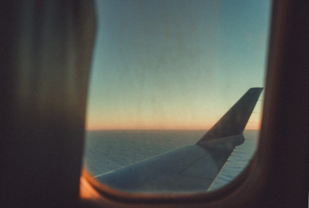 Image for e1 and e2 treaty investor visas; an airplane window view from the inside.