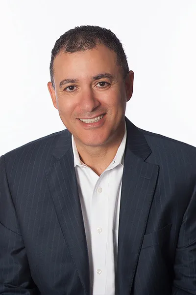 Image of Sam Shihab immigration lawyer. This is an image of Sam Shihab on a white background. Sam is wearing a striped dark blue business suit and a white shirt.