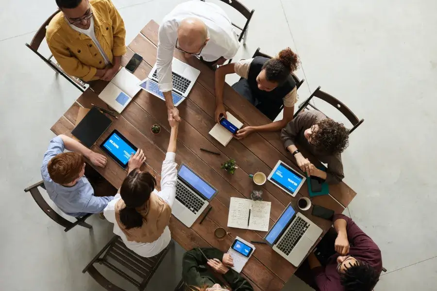 Image of executives sitting around a table with their computers and paperwork. The image is supposed to be a representation of the l-1a visa immigration lawyers that help executives get their L-1A visa.
